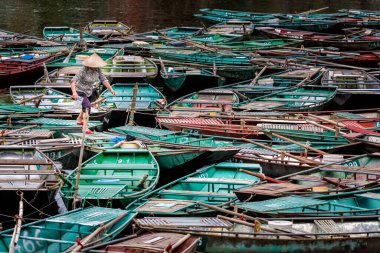 Vietnamlı konik şapkalı güzel manzara ve Ulusal Park Tam Coc 'ta tekneler, Vietnam' da Ninh Binh. Güneydoğu Asya 'da çekilmiş kırsal manzara fotoğrafı..