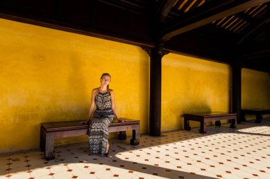 Young caucasian pretty woman in Beautiful architecture photo of Imperial city - citadel Hue, Vietnam. Popular visitors place with no tourist.