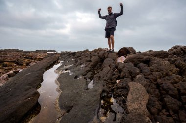 Young handsome male tourist in Bai Tam beach, Quan Lan island, Bai Tu Long Bay, Vietnam. Seaside scenery photo taken in south east Asia, Ha Long area.