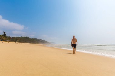 Handsome man in Quan Lan beach - Bai Bien - island, Bai Tu Long Bay, Vietnam. Seaside scenery photo taken in south east Asia, Ha Long area.
