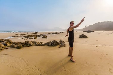 Tourist with Beautiful landscape of Quan Lan beach - Bai Bien - island, Bai Tu Long Bay, Vietnam. Seaside scenery photo with fog taken in south east Asia, Ha Long area.