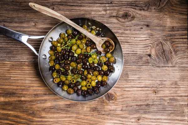 Сковородка со свежими оливками — стоковое фото