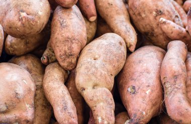 Fresh local sweet potatoes at the market clipart