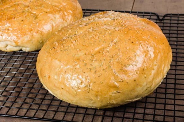 Artisan rosemary bread on cooling rack — Stock Photo, Image