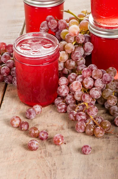 Pink grapes with stacked jars of jelly — Stock Photo, Image