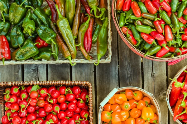 Diverse paprika's in verschillende manden — Stockfoto