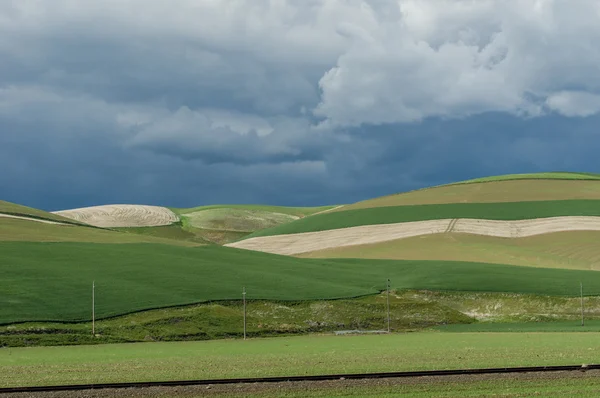 Роллінг зелених полів ферми з розлюченим штормом — стокове фото