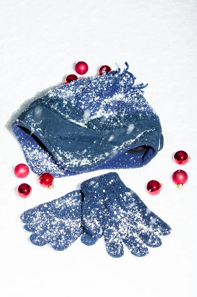 Casquette et gants dans la neige avec boules rouges — Photo