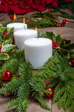 Beyaz mumlar ve poinsetti yaprak dökmeyen Noel centerpiece