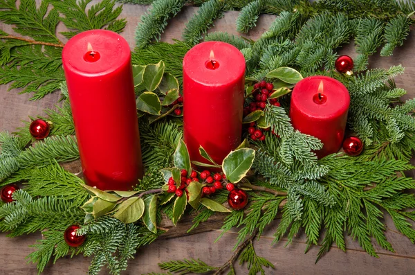 Red candles in Christmas evergreen arrangement — Stock Photo, Image