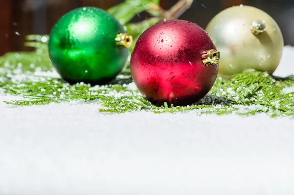 Adornos navideños sobre nieve con cedro —  Fotos de Stock