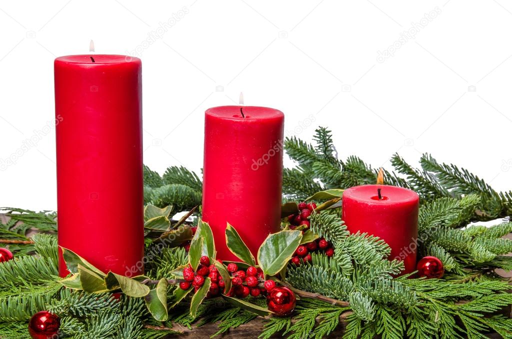 Red candles with cedar boughs and holly