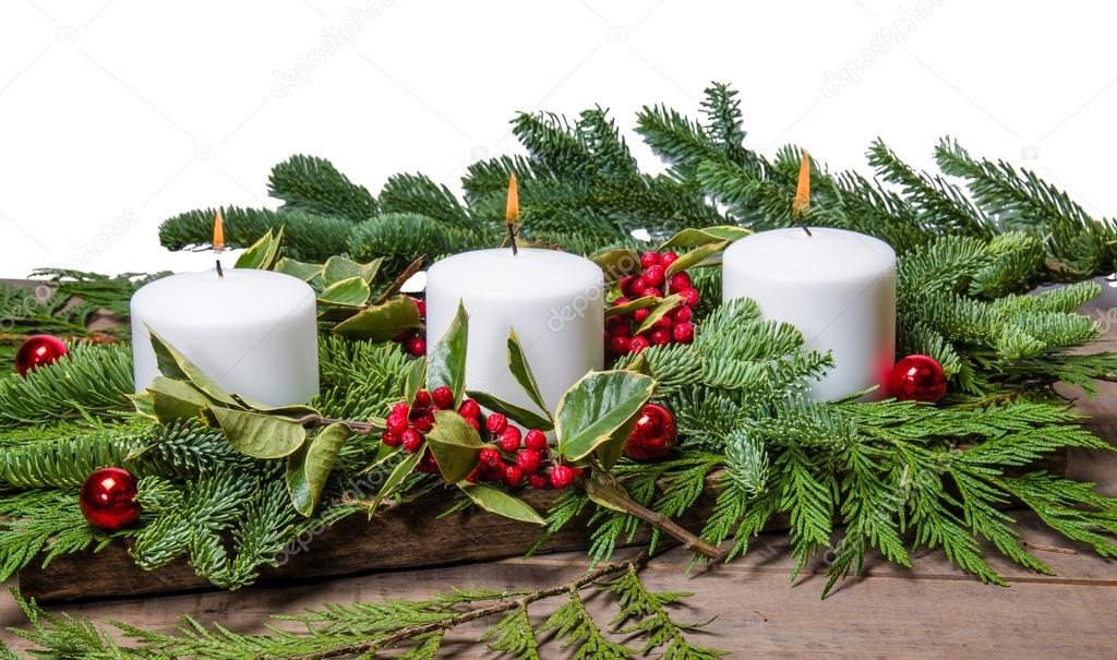 Burning white candles with boughs