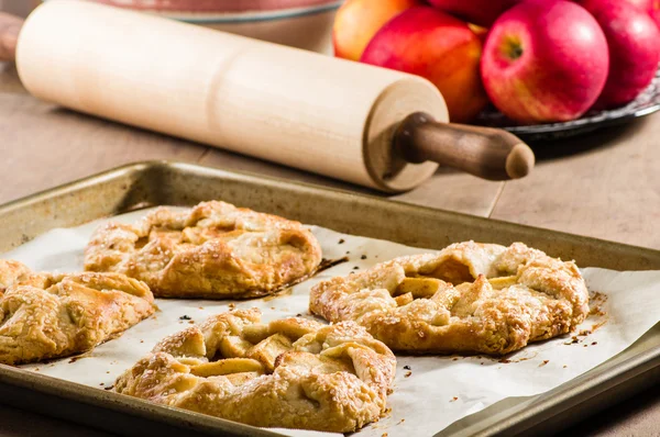 Warm apple tarts with rolling pin — Stock Photo, Image