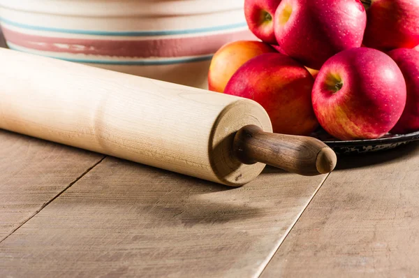 Bowl of apples with a rolling pin — Stock Photo, Image