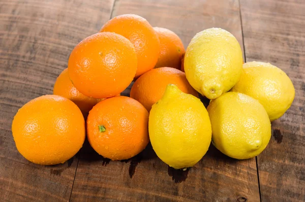 Цитрусовые апельсины и лимоны на столе — стоковое фото