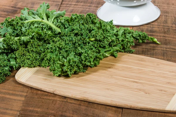 Green curly kale on cutting board — Stock Photo, Image