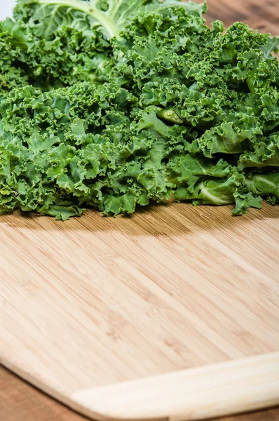 Green curly kale on cutting board — Stock Photo, Image