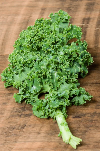 Green curly kale leaf on table — Stock Photo, Image