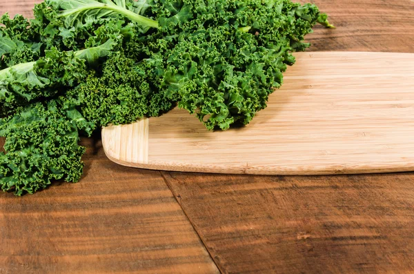 Curly kale leaves on cutting board — Stock Photo, Image