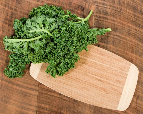 Curly kale leaves on cutting board — Stock Photo, Image