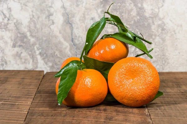 Ripe tangelos with leaves on table — Stock Photo, Image