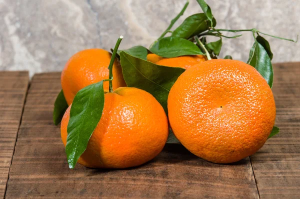 Ripe tangelos with leaves on table — Stock Photo, Image