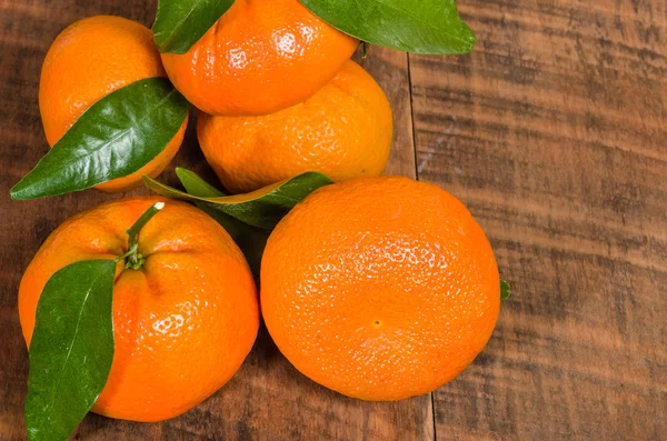 Tangelos met groene bladeren op tafel — Stockfoto