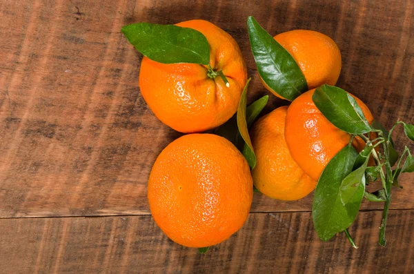 Tangelos met groene bladeren op tafel — Stockfoto