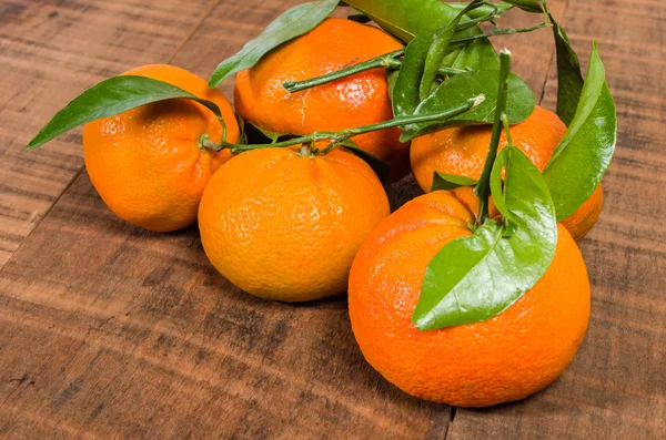 Tangelos met groene bladeren op tafel — Stockfoto