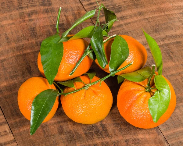 Tangelos met groene bladeren op tafel — Stockfoto