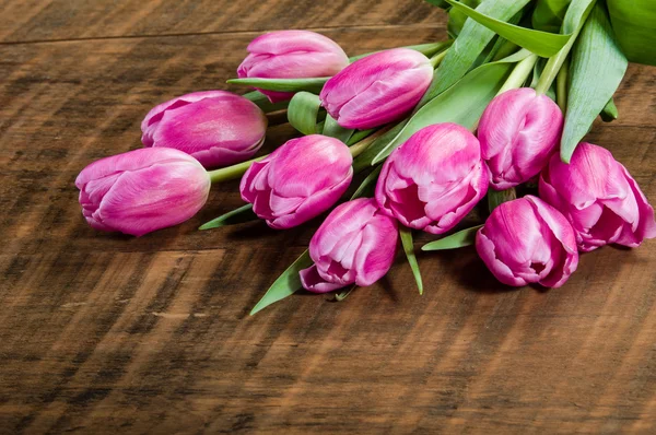 Bouquet of pink tulips on a wooden table — Stock Photo, Image