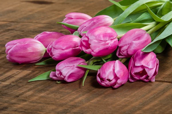 Bouquet of pink tulips on a wooden table — Stock Photo, Image