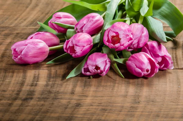 Bouquet of pink tulips on a wooden table — Stock Photo, Image