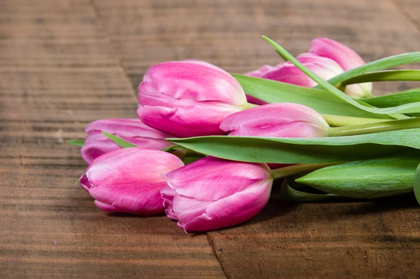 Bouquet of pink tulips on a wooden table — Stock Photo, Image