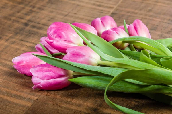 Bouquet of pink tulips on a wooden table — Stock Photo, Image