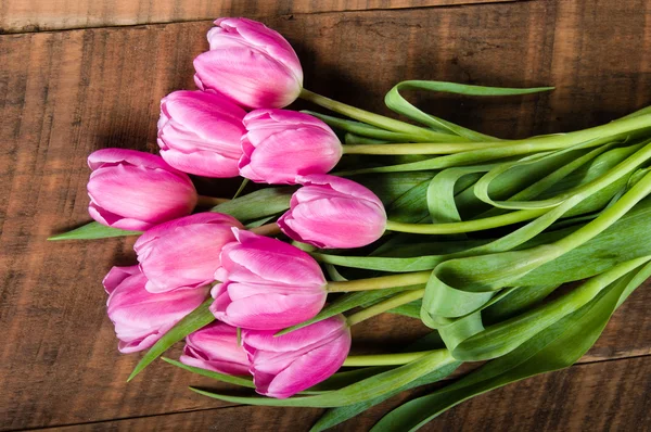 Букет з рожевих тюльпанів на дерев'яному столі — стокове фото