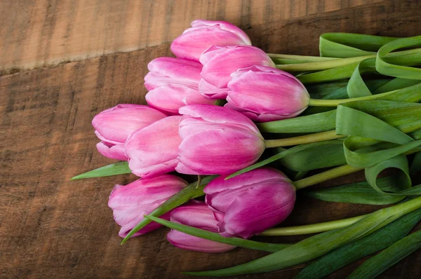 Bouquet of pink tulips on a wooden table — Stock Photo, Image