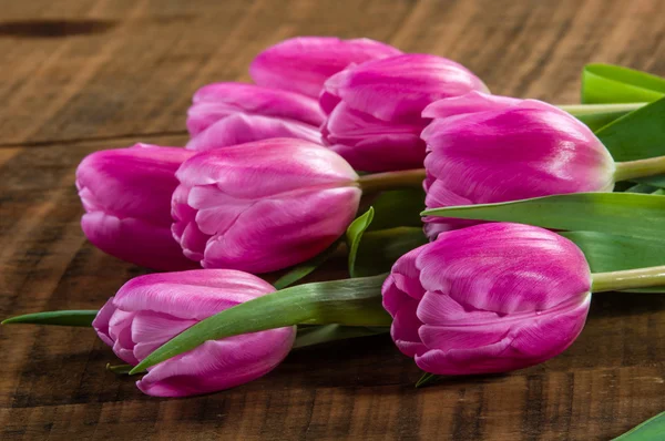 Bouquet de tulipes roses sur une table en bois — Photo
