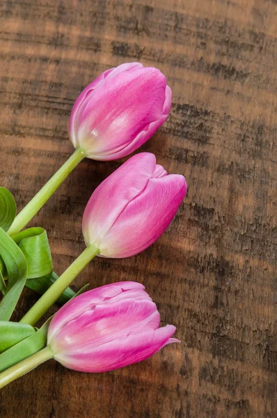 Bouquet of pink tulips on a wooden table — Stock Photo, Image