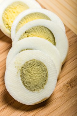 Katı pişmiş yumurta kesme tahtası üzerinde dilimlenmiş
