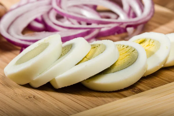 Hard boiled eggs sliced with red onion — Stock Photo, Image