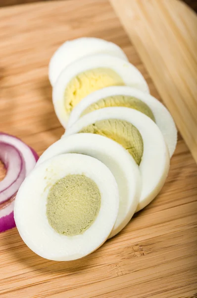 Sliced hard boiled egg on cutting board — Stock Photo, Image