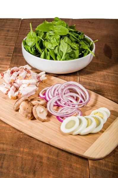 Bowl of green spinach with ingredients — Stock Photo, Image