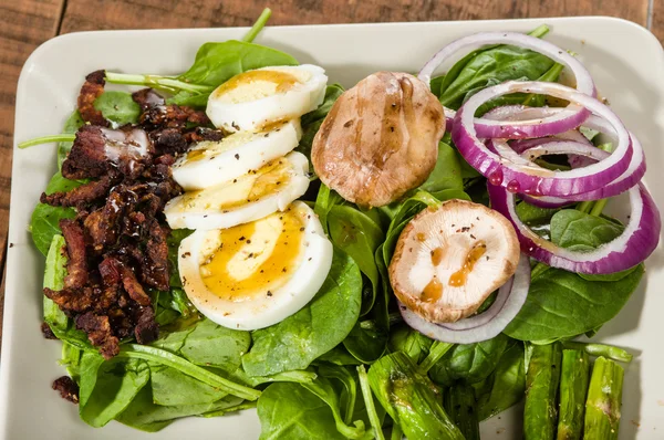 Spinach and egg salad with bacon bits — Stock Photo, Image