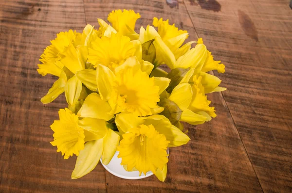 Daffodil flowers in a white can — Stock Photo, Image