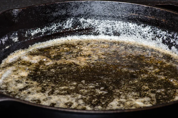 Чугунная сковорода с маслом — стоковое фото