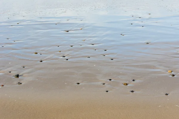 Padrões na areia molhada causada pela água — Fotografia de Stock