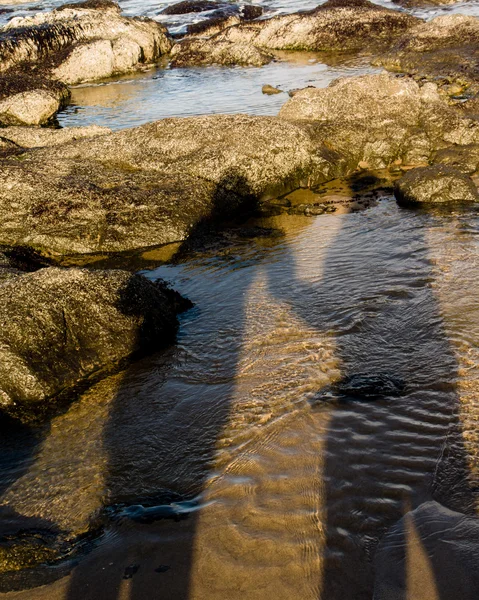 Ombra di una coppia che si tiene per mano sulla spiaggia — Foto Stock