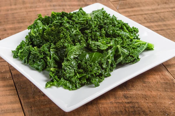 Kale greens on white plate — Stock Photo, Image